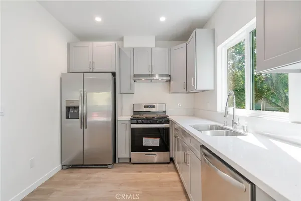 a kitchen with stainless steel appliances granite countertop a sink stove and refrigerator