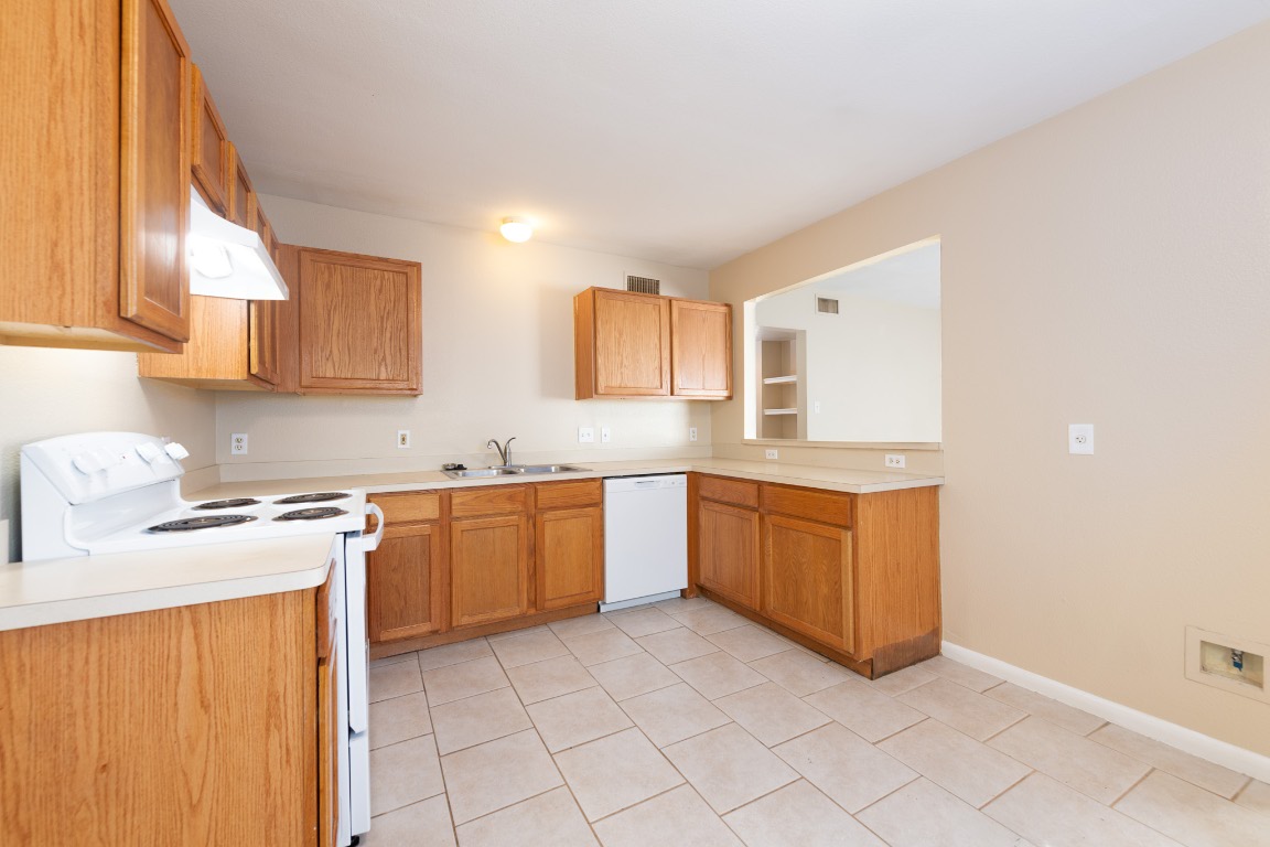 Undisclosed Address Austin, TX 78752 - Photo 5 of 13 a kitchen with granite countertop a sink stove and cabinets