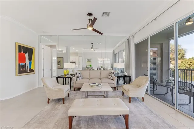 a living room with furniture kitchen view and a wooden floor