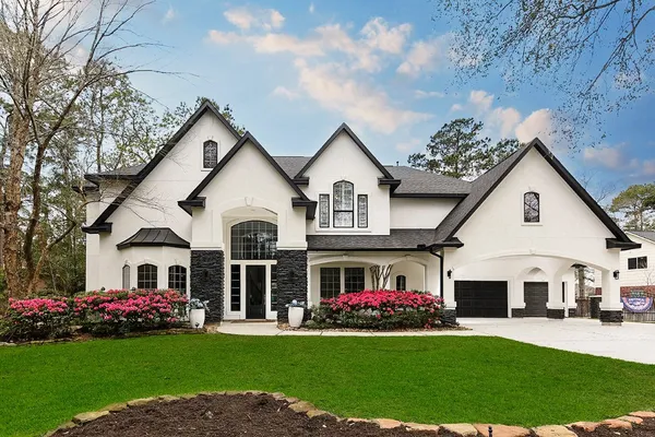 a front view of a house with a garden and yard