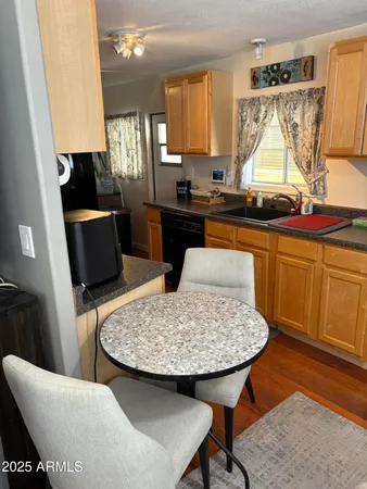 a kitchen with a sink a window and chairs