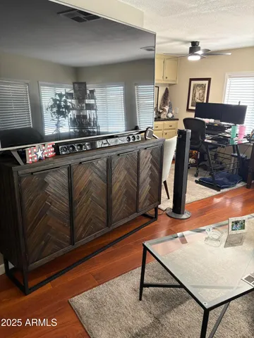 a living room with furniture a rug and kitchen view
