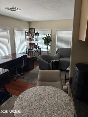 a living room with furniture a bookshelf and a window
