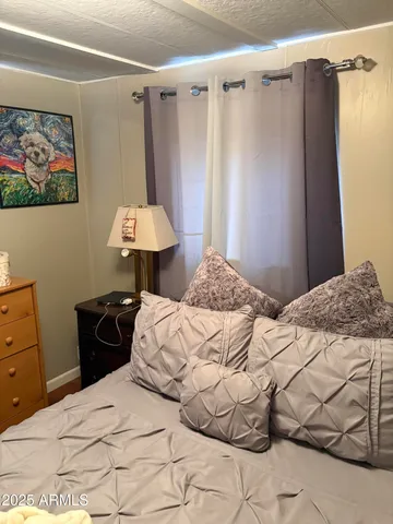 a bedroom with a bed and a painting on the wall