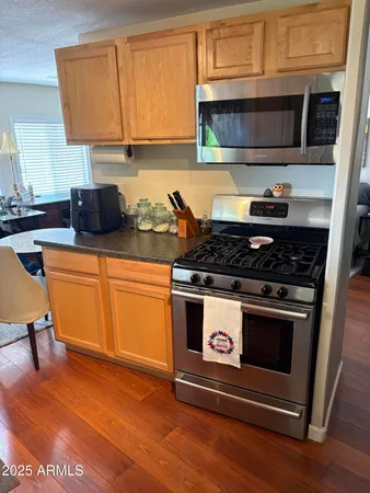 a kitchen with a sink a window and chairs