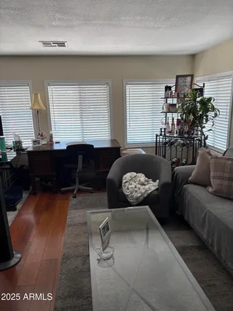 a living room with furniture and a wooden floor