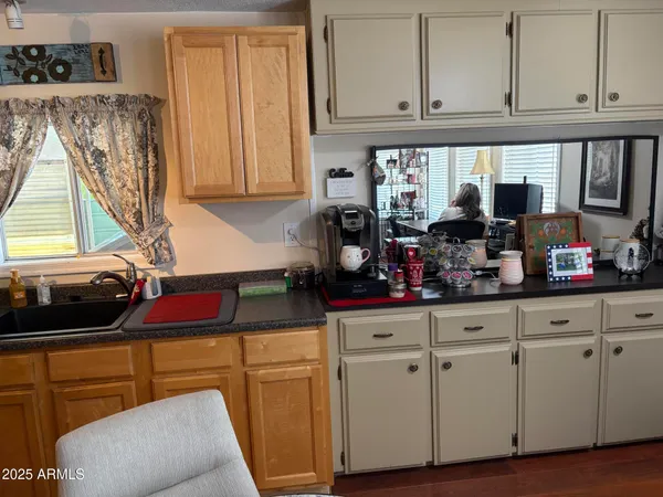 a kitchen with white cabinets and window