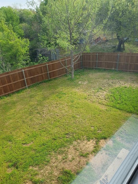 9821-9823 Sycamore Street Little Elm, TX 75068 - Photo 5 of 7 a view of a yard with a wooden fence