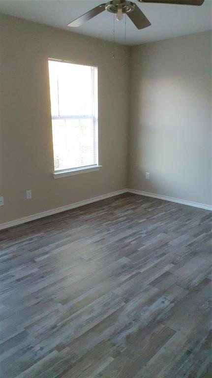 9821-9823 Sycamore Street Little Elm, TX 75068 - Photo 7 of 7 an empty room with wooden floor and windows