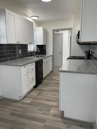 a kitchen with granite countertop a sink and a stove