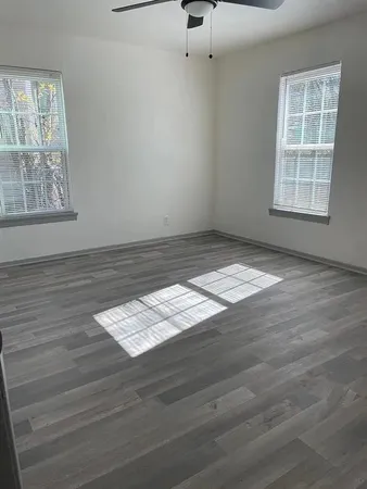 wooden floor in an empty room with a window