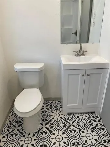 a bathroom with a toilet a sink and a mirror