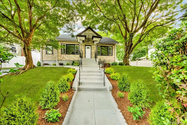 a front view of a house with yard and green space