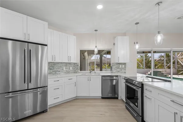 a kitchen with stainless steel appliances a refrigerator sink and cabinets