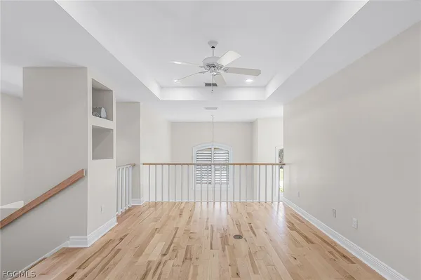 a view of a room with wooden floor fan and windows