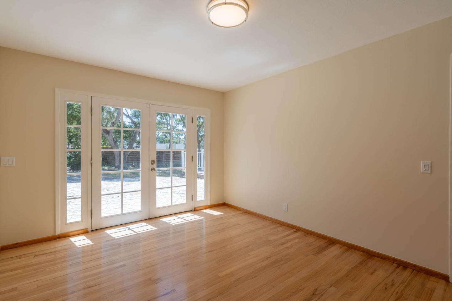 1044 Lost Barranca Road Pebble Beach, CA 93953 - Photo 12 of 15 a view of an empty room with wooden floor and a window