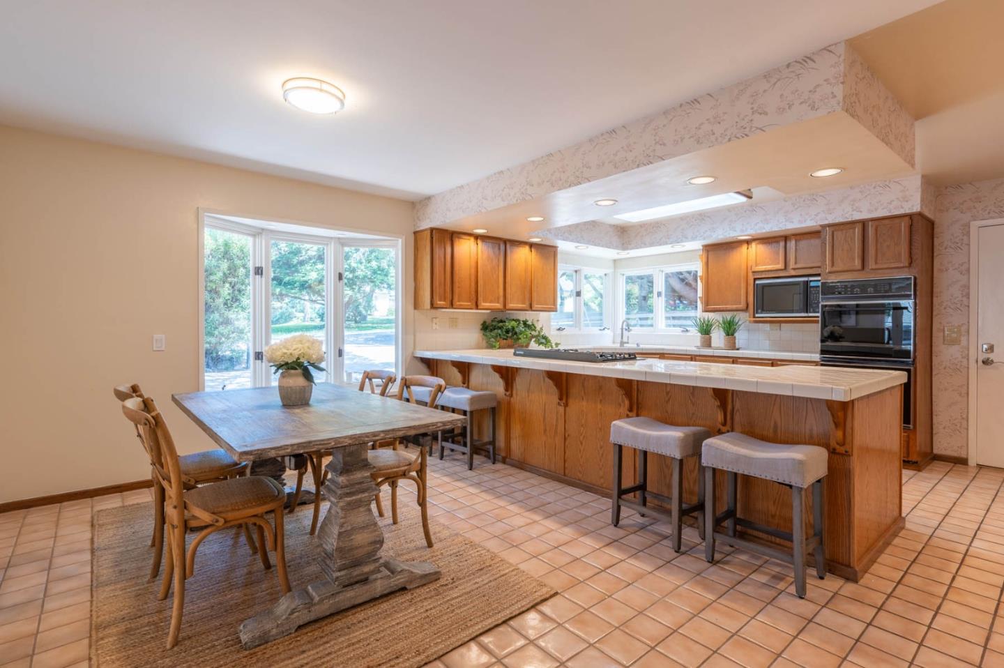 1044 Lost Barranca Road Pebble Beach, CA 93953 - Photo 5 of 15 a kitchen with granite countertop a table chairs sink and microwave