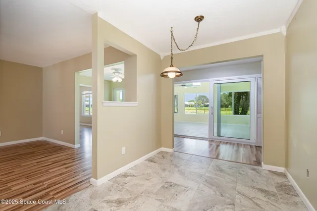 a view of a hallway with wooden floor and a living room