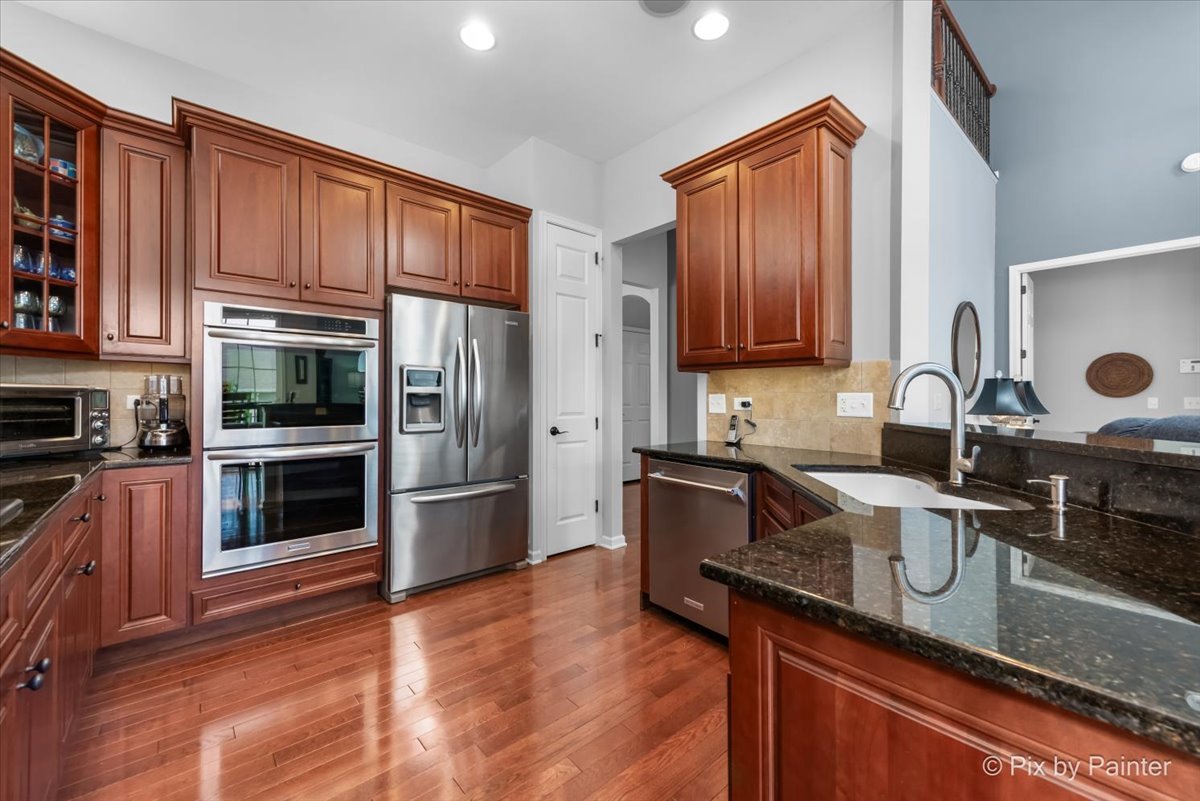 3879 Seigle Drive Elgin, IL 60124 - Photo 7 of 44 a kitchen with granite countertop stainless steel appliances and wooden cabinets