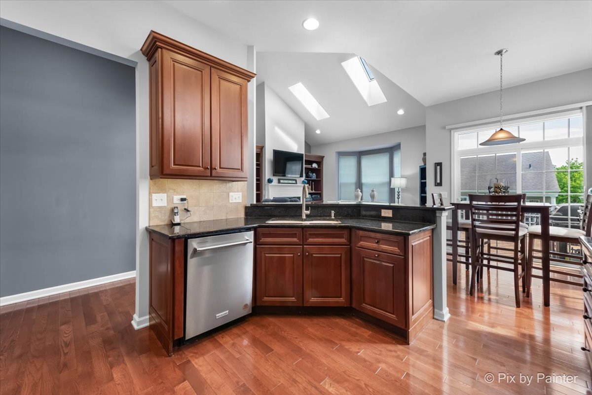 3879 Seigle Drive Elgin, IL 60124 - Photo 8 of 44 a kitchen with stainless steel appliances granite countertop wooden cabinets a sink a stove a dining table and chairs