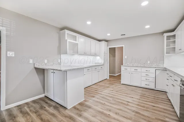a kitchen with stainless steel appliances kitchen island hardwood floor sink and cabinets