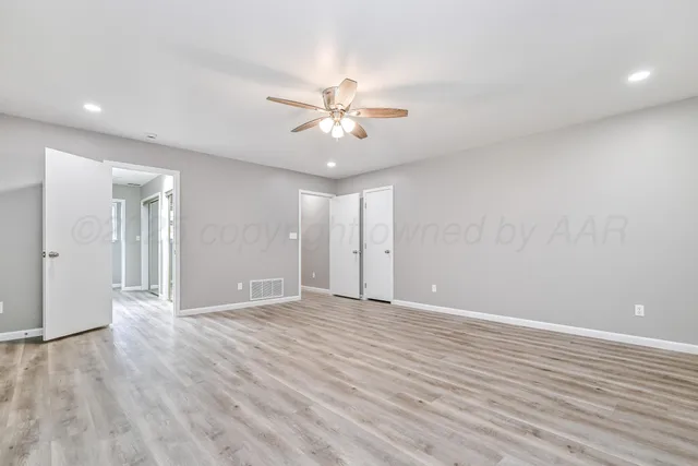 a view of an empty room with wooden floor