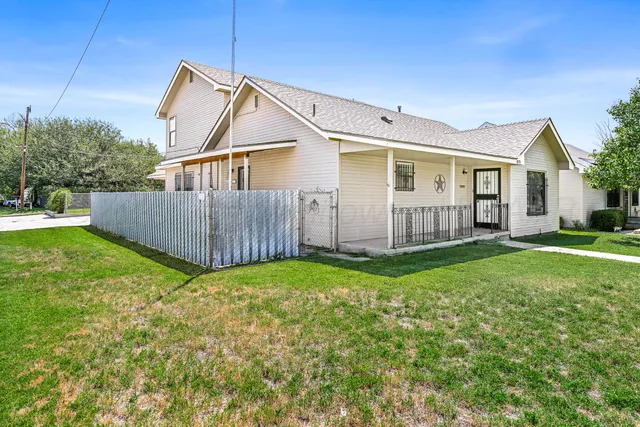 a view of a house with backyard and sitting area