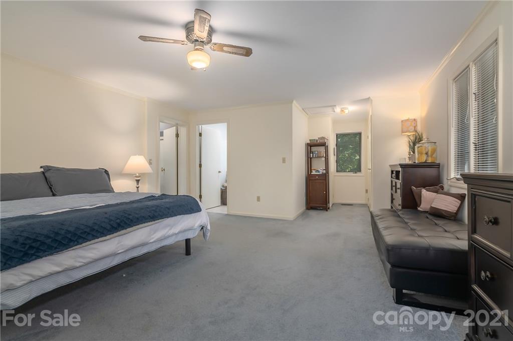 15 Doubleday Road Tryon, NC 28782 - Photo 25 of 46 a spacious bedroom with a bed a couch and a chandelier