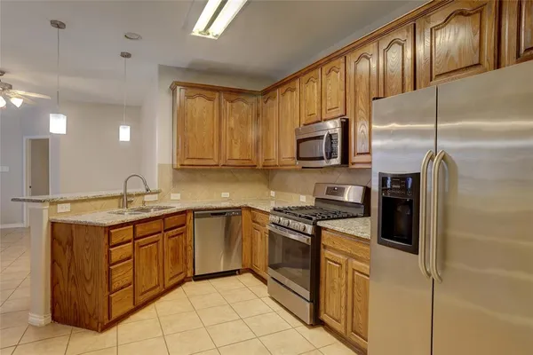 a kitchen with stainless steel appliances granite countertop a stove a sink and a refrigerator