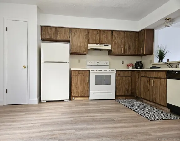 a kitchen with stainless steel appliances a sink a stove a refrigerator and cabinets
