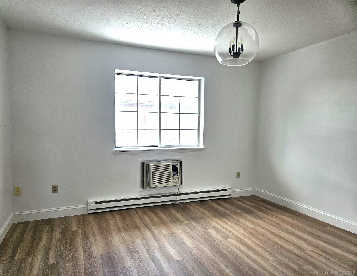 975 Meriden Road, Unit 11 Waterbury, CT 06705 - Photo 20 of 27 a view of an empty room with wooden floor and a window