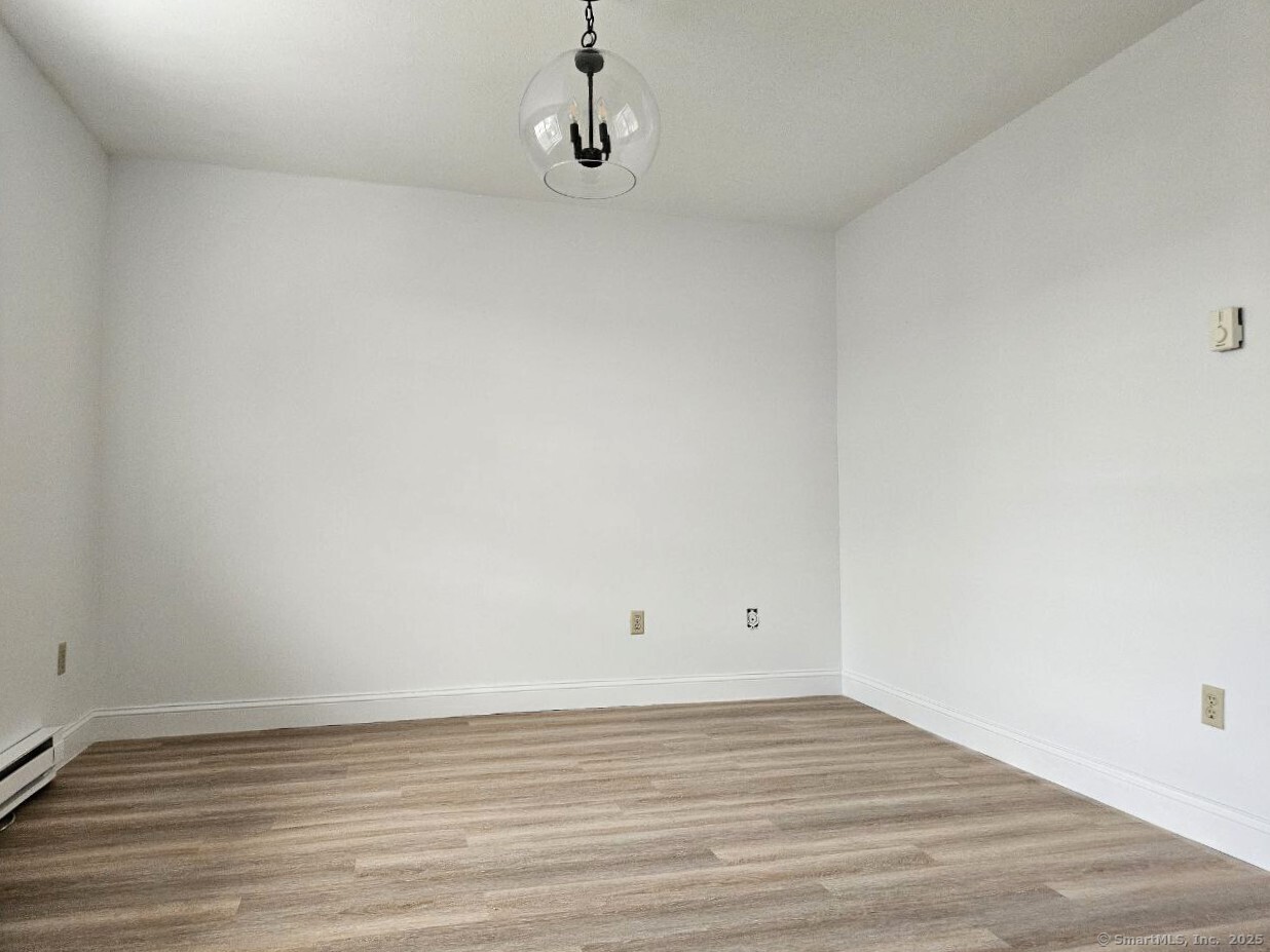 975 Meriden Road, Unit 11 Waterbury, CT 06705 - Photo 21 of 27 a view of an empty room with wooden floor
