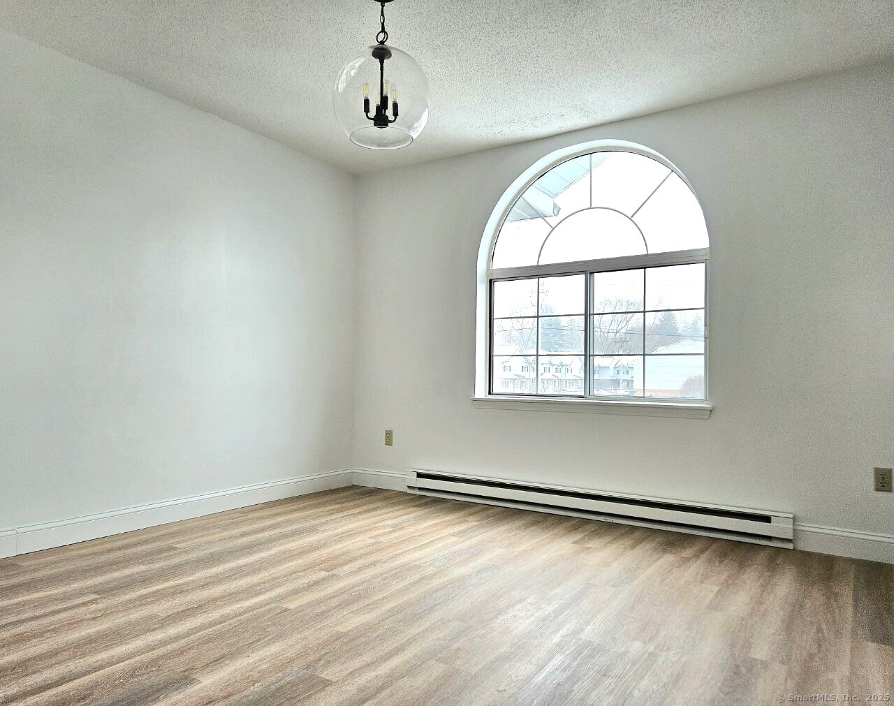 975 Meriden Road, Unit 11 Waterbury, CT 06705 - Photo 25 of 27 an empty room with wooden floor and windows
