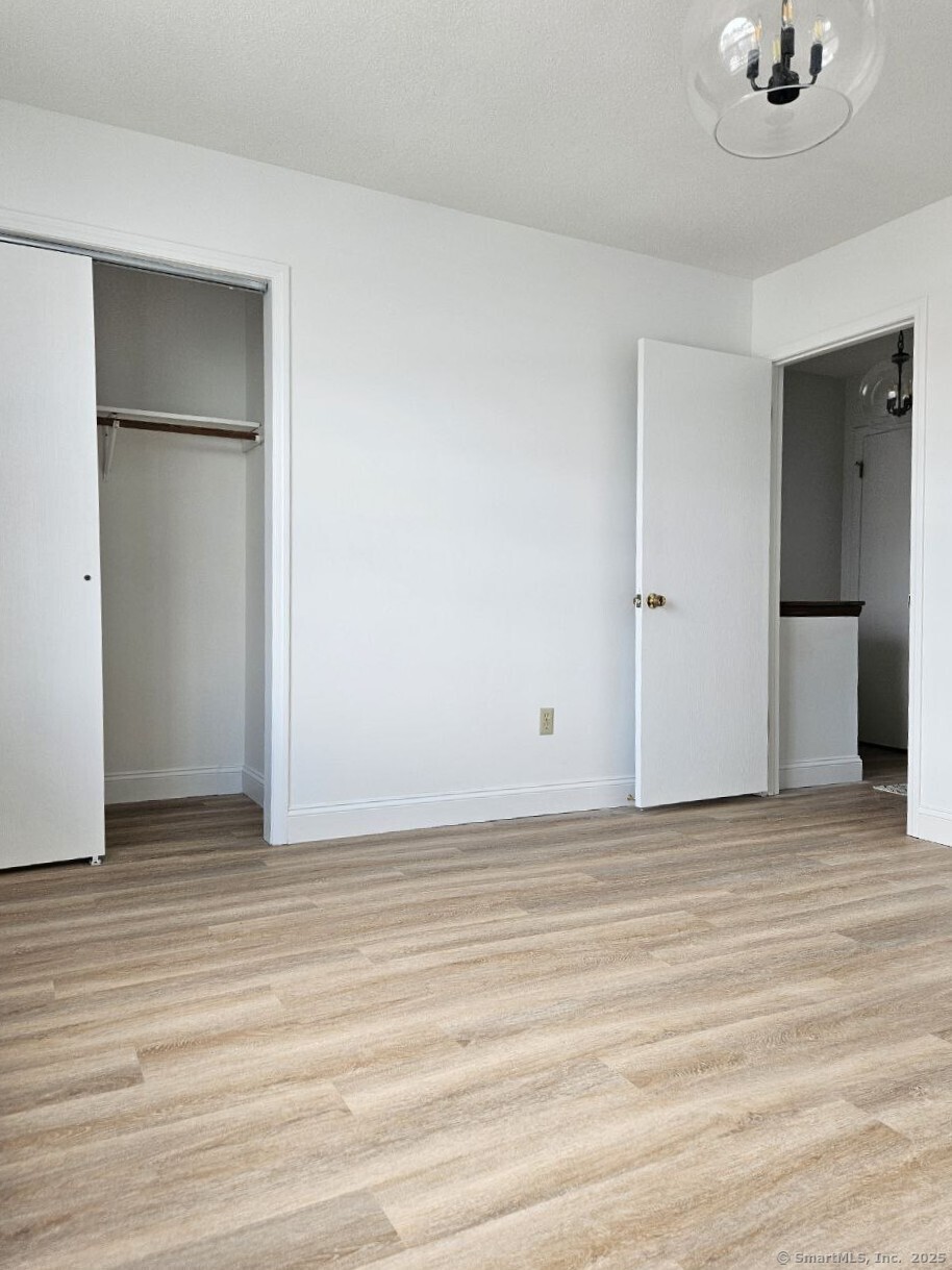 975 Meriden Road, Unit 11 Waterbury, CT 06705 - Photo 7 of 27 a view of an empty room with wooden floor