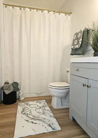 a bathroom with a toilet and a shower curtain