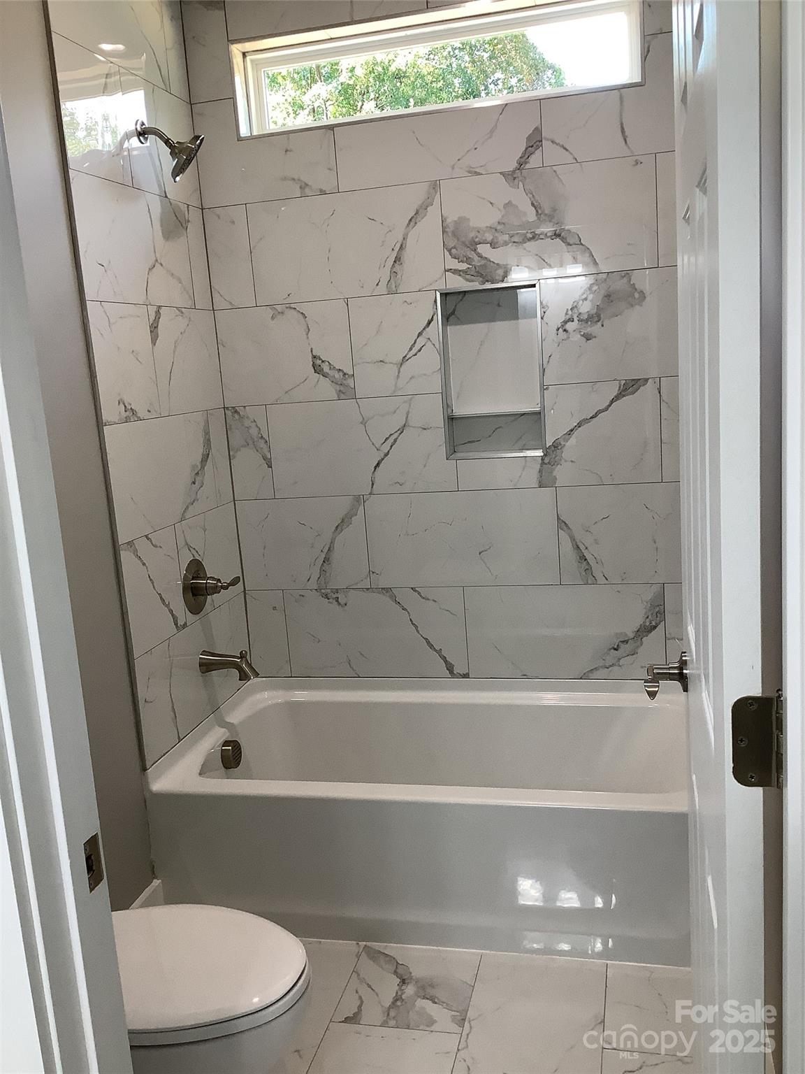 302 West 2nd Street Lowell, NC 28098 - Photo 15 of 17 a bathroom with a bathtub and a toilet