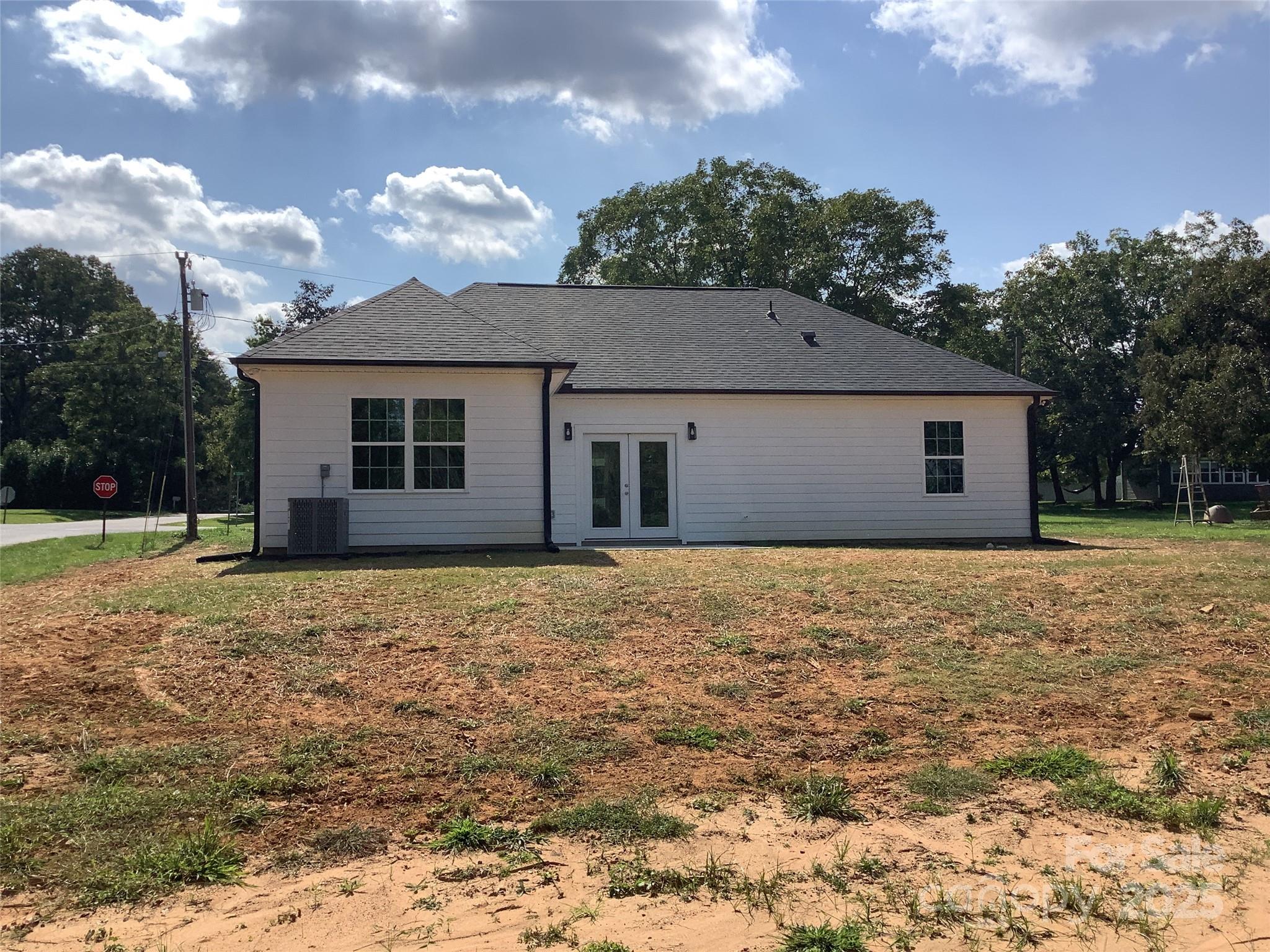 302 West 2nd Street Lowell, NC 28098 - Photo 17 of 17 a house with trees in the background