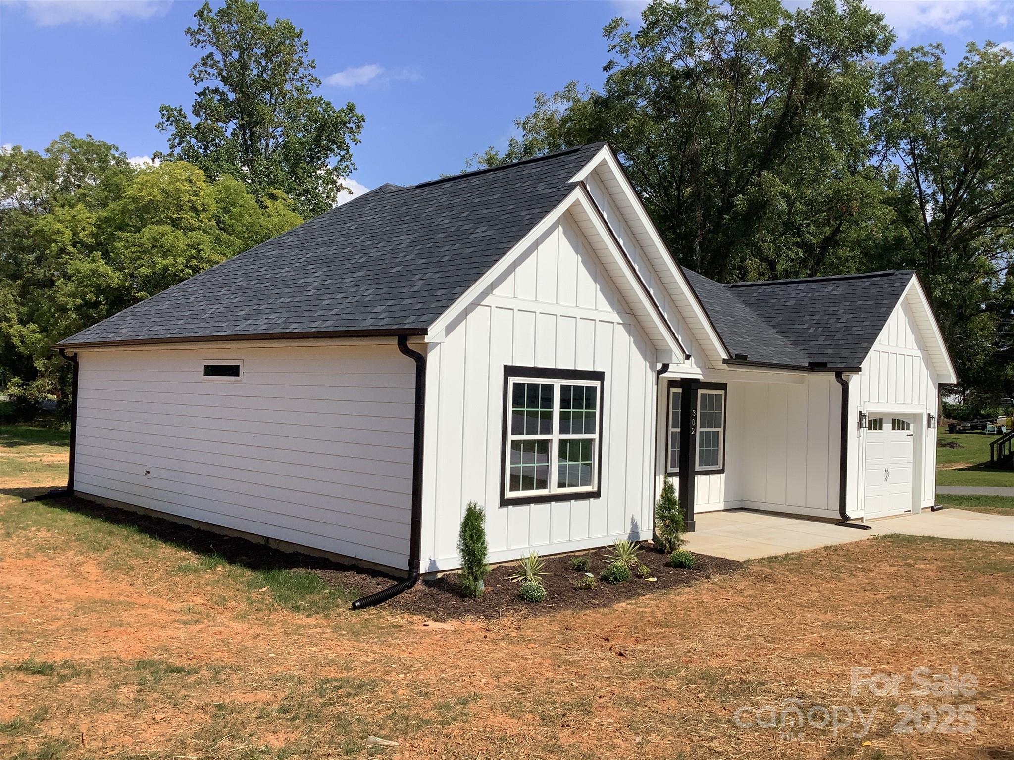 302 West 2nd Street Lowell, NC 28098 - Photo 3 of 17 a view of a house with a yard and garage