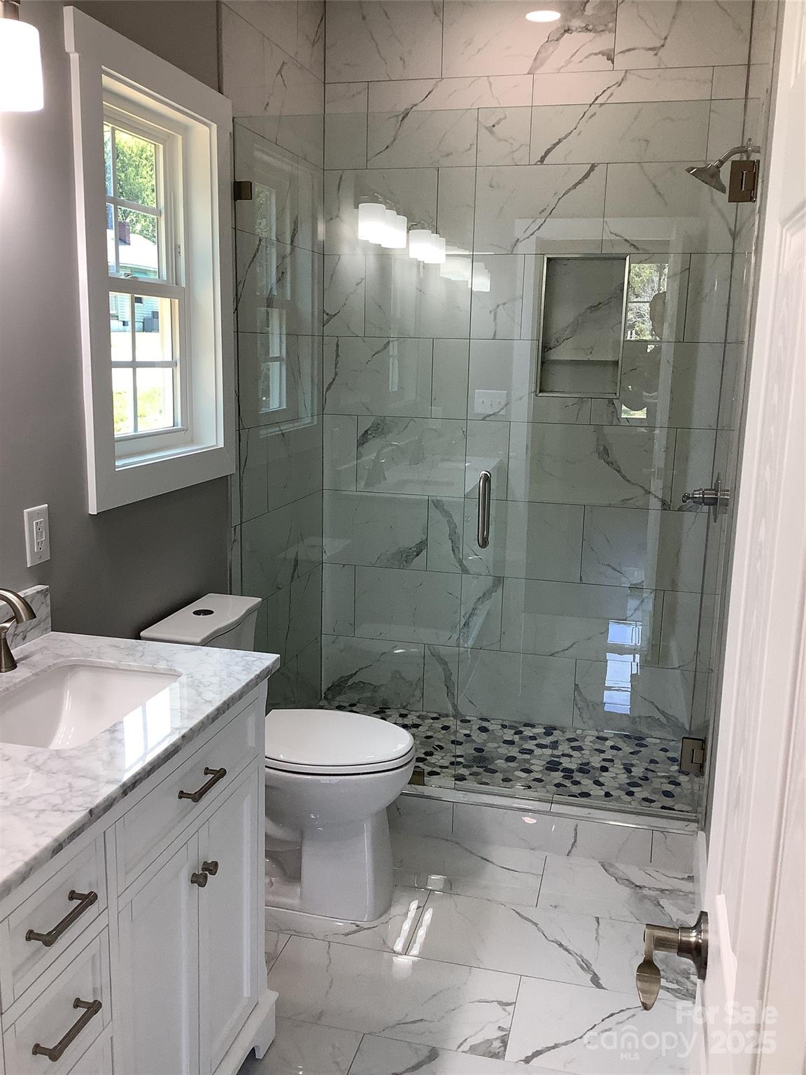 302 West 2nd Street Lowell, NC 28098 - Photo 9 of 17 a bathroom with a sink toilet and shower