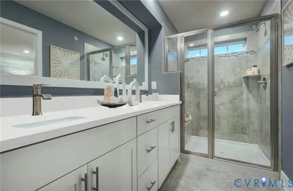 a bathroom with double vanity and a shower