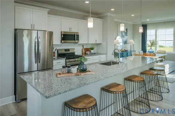 a kitchen with stainless steel appliances granite countertop a sink refrigerator and microwave