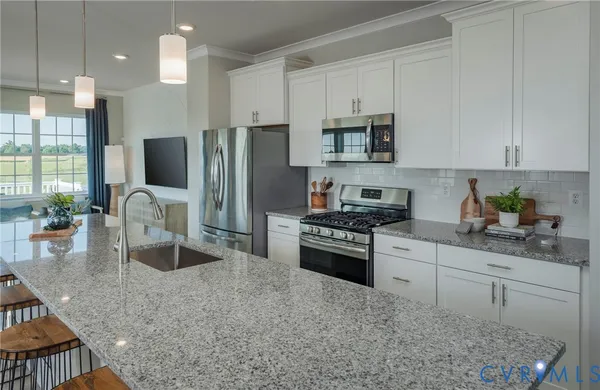 a kitchen with stainless steel appliances granite countertop a stove refrigerator sink and cabinets
