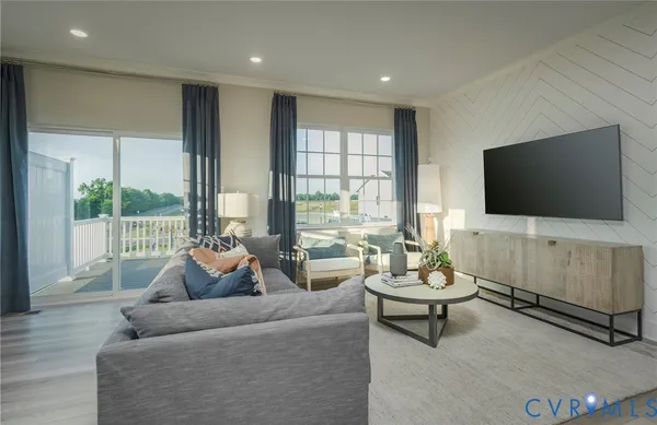 a living room with furniture a flat screen tv and a floor to ceiling window
