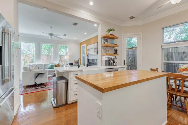 a large kitchen with stainless steel appliances a stove a refrigerator a sink dishwasher with a dining table and chairs