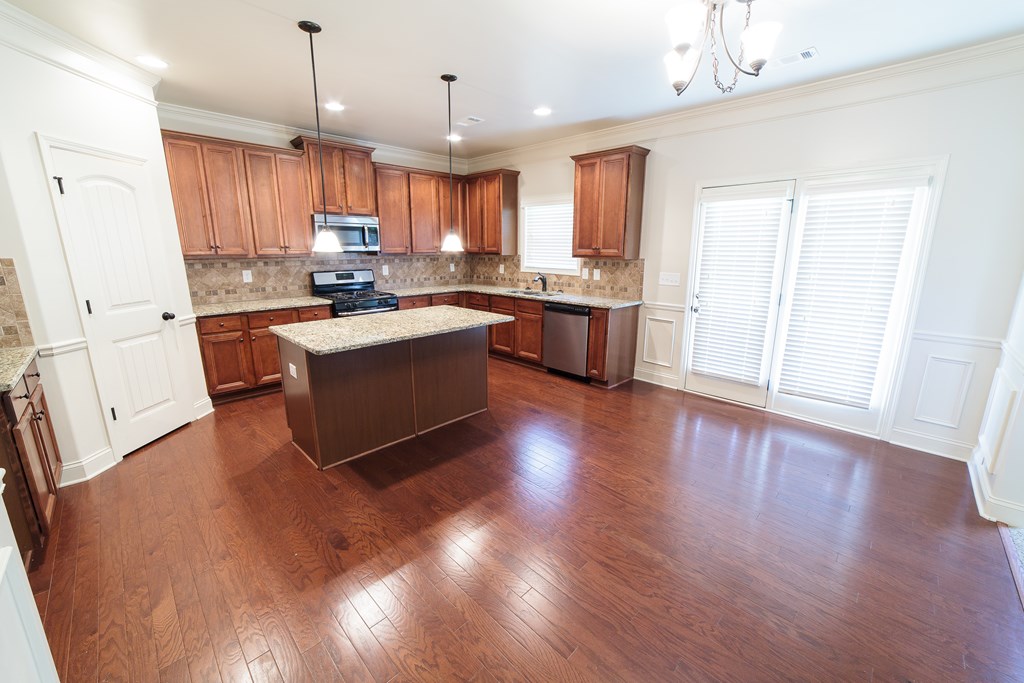 82 Riverside Landing Fort Mitchell, AL 36856 - Photo 16 of 47 a kitchen with kitchen island granite countertop wooden floors and stainless steel appliances