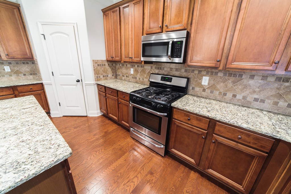 82 Riverside Landing Fort Mitchell, AL 36856 - Photo 18 of 47 a kitchen with stainless steel appliances granite countertop a stove a sink and a microwave