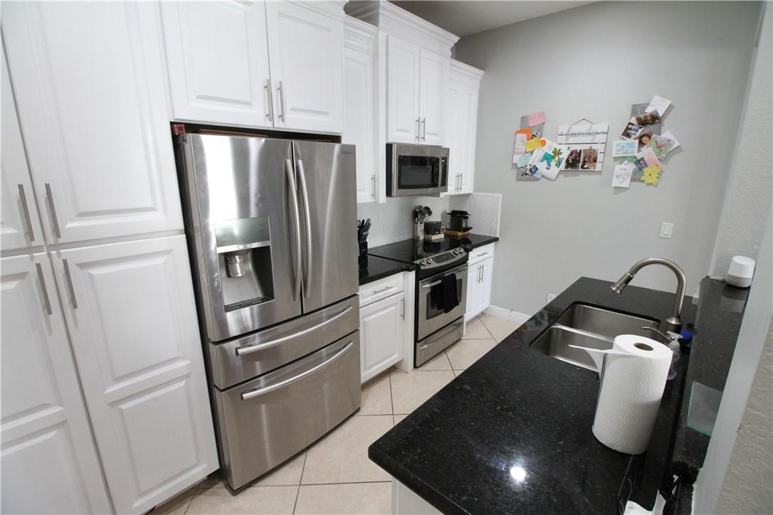 8316 Northwest 8th Terrace Boca Raton, FL 33487 - Photo 12 of 34 a kitchen with a refrigerator and cabinets
