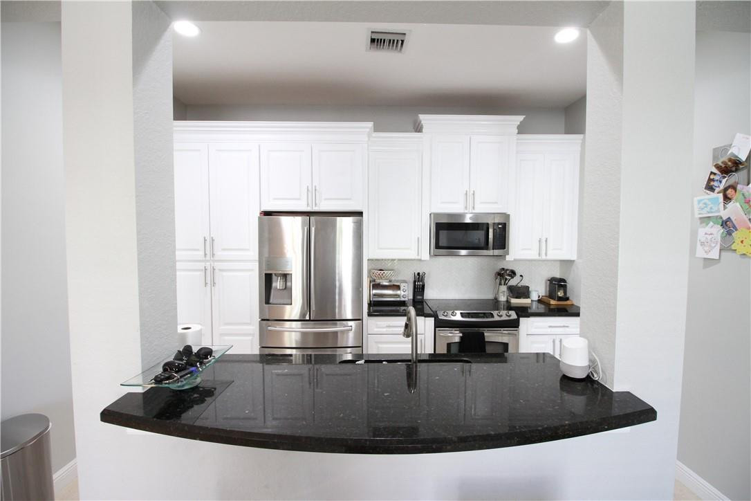 8316 Northwest 8th Terrace Boca Raton, FL 33487 - Photo 13 of 34 a kitchen with kitchen island a sink and stainless steel appliances