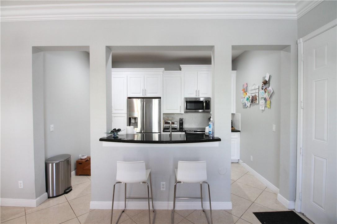 8316 Northwest 8th Terrace Boca Raton, FL 33487 - Photo 10 of 34 a kitchen with stainless steel appliances kitchen island granite countertop a table and chairs in it
