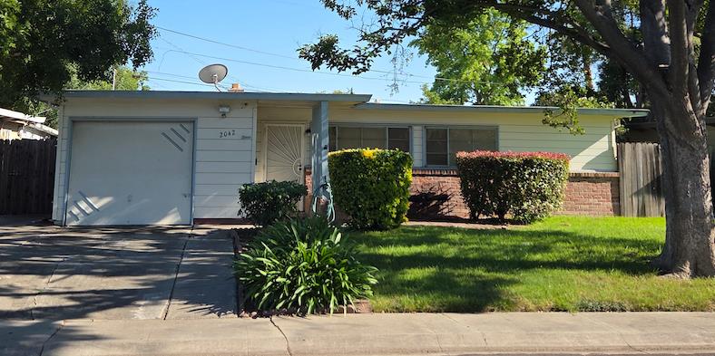 2042 Rutledge Way Stockton, CA 95207 - Photo 1 of 1 Ranch-style residence featuring a concrete driveway, a front lawn, and mature landscaping